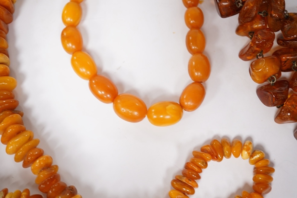Three assorted amber necklaces including a single strand graduated oval bead necklace, 40cm, gross weight 37 grams, the other two necklaces gross weight 240 grams. Condition - poor to fair